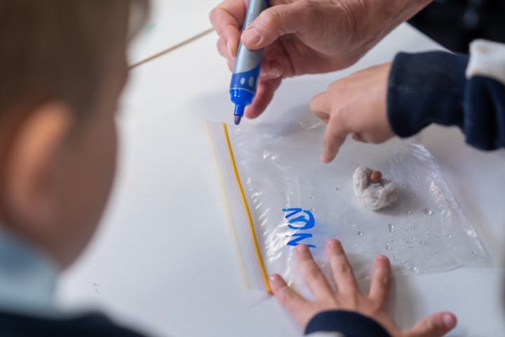 Students marking a seed in a bag