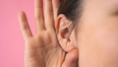 Student holds hand up to ear