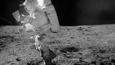 An astronaut on an Apollo mission, walking on the moon in full spacesuit. 