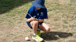 A student explores toy rollers made and played with by First Nations children in inland Australia