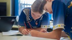 Students writing in their books. 