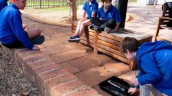 Classmates observe as a student sets up a pulling experiment