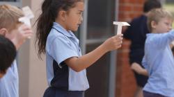 Students throwing paper gliders