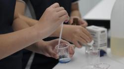 Student adding liquid to beaker