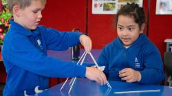 Two students work together to build a pyramid-type structure