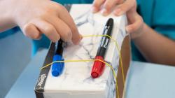 Student plucks elastic band