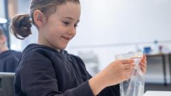 Student examines item in a sealed bag