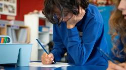 Students at a table take notes