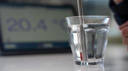 A glass of water with a metal straw